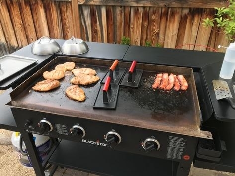 reviewer photo of a grill with three of the grill presses and chicken breasts
