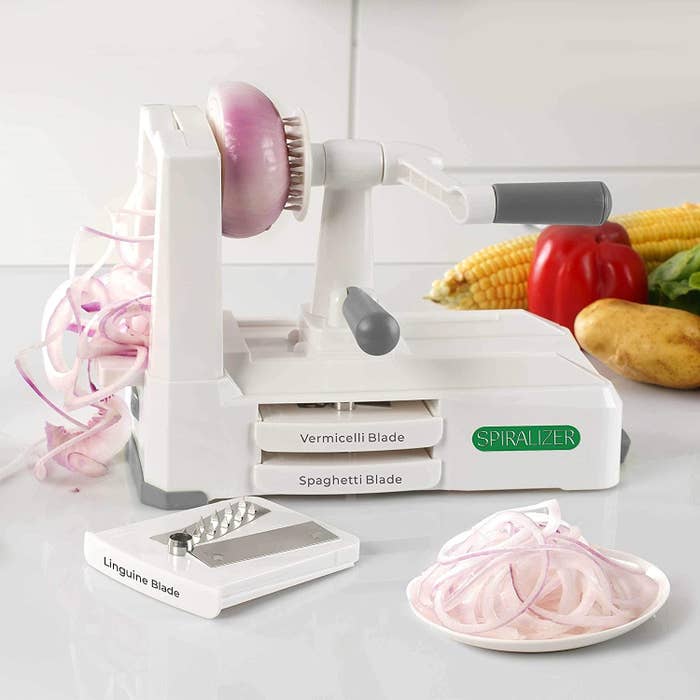 vegetable spiralizer with a crank, with an onion being spiralized