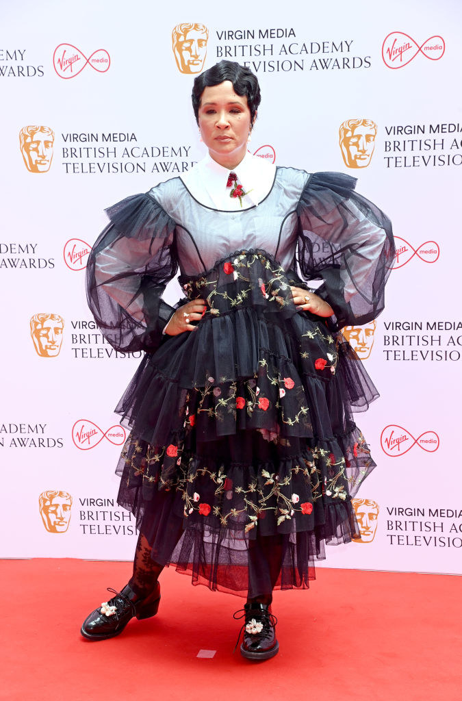 Golda Rosheuvel attends the Virgin Media British Academy Television Awards 2021 in a multi-layered print and lace dress with lacy tights and a blouse underneath