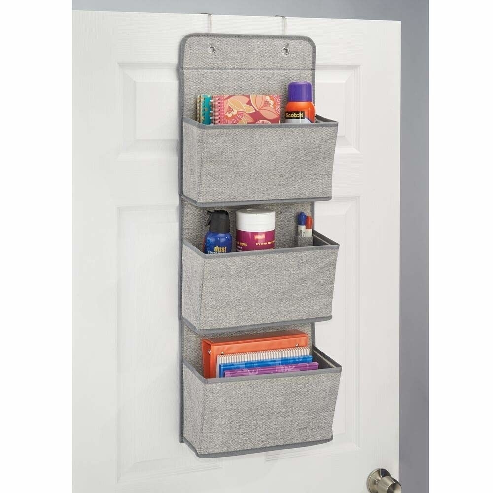 A grey organiser on a door with different items on each tier 