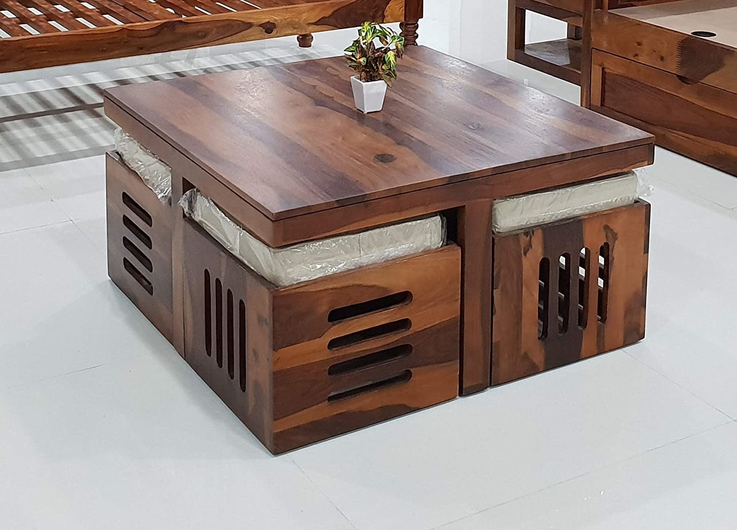 A wooden coffee table with stools underneath it 