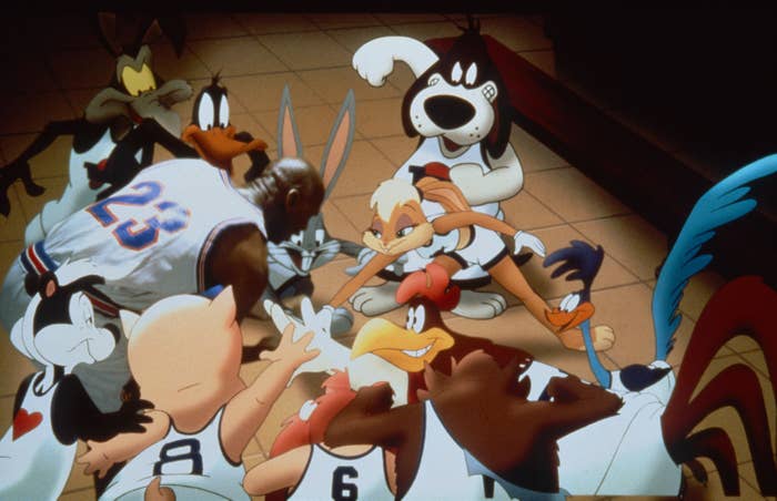On set of the 1996 "Space Jam" film, Wile E Coyote, Daffy Duck, Michael Jordan, Bugs Bunny, Lola Bunny, the Road Runner, Foghorn Leghorn, Tazmanian Devil, Yosemite Sam, Porky Pig, and Pepe Le Pew put their hands together in cheer
