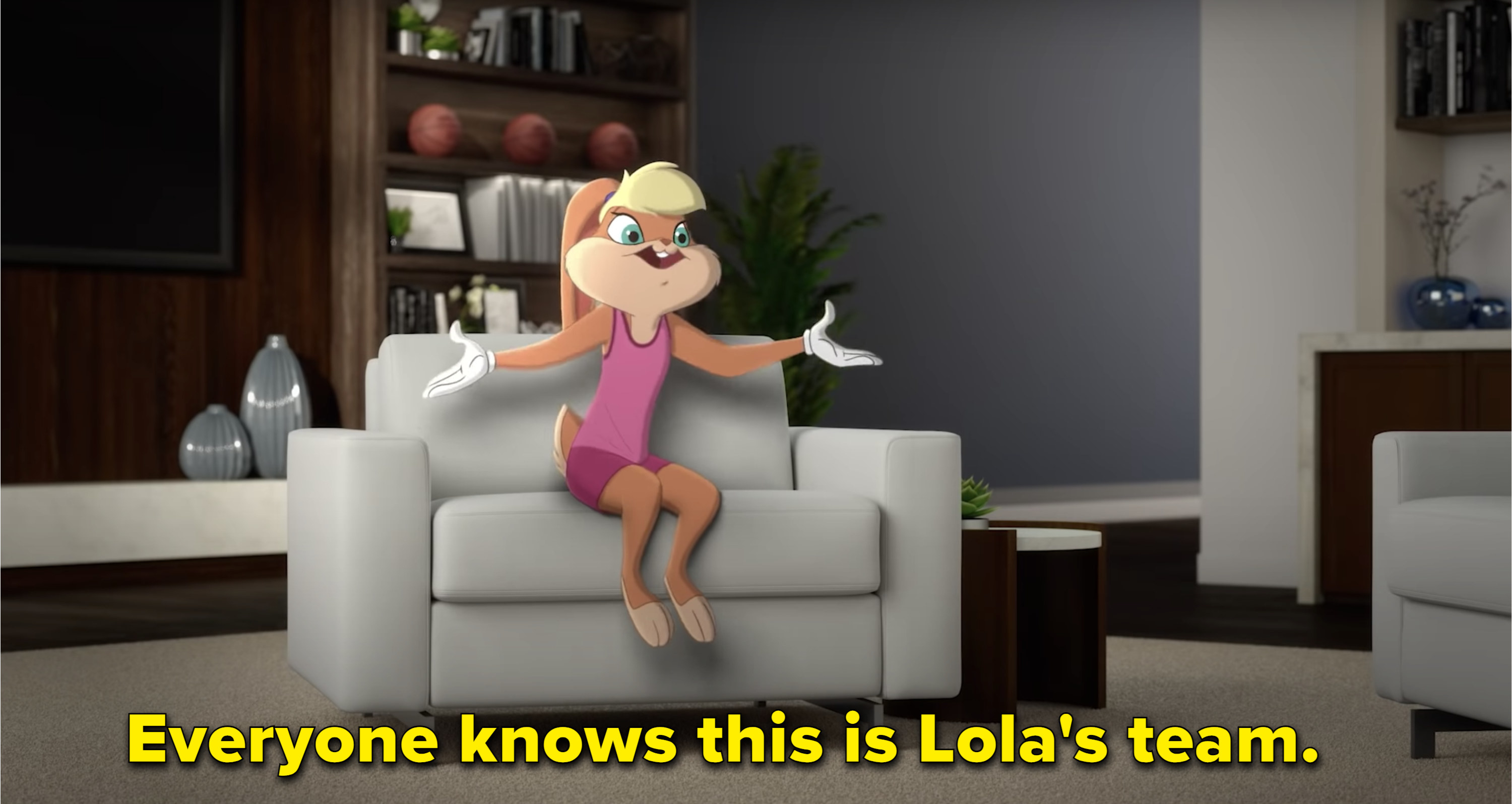 The 2021 Lola Bunny sits on a armchair in a chic room, her arms extended for effect