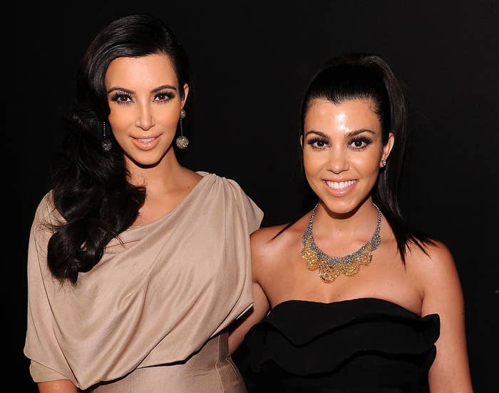 Kim and Kourtney smile while attending an event