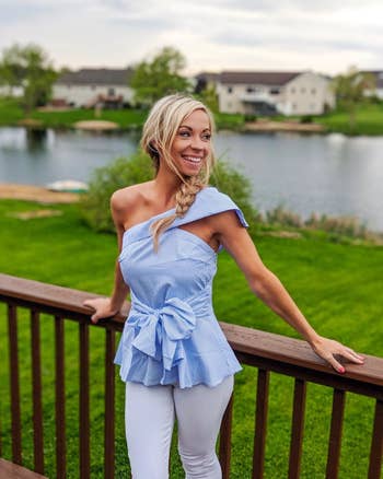 Reviewer wearing striped one shoulder ruffled bow tie shirt