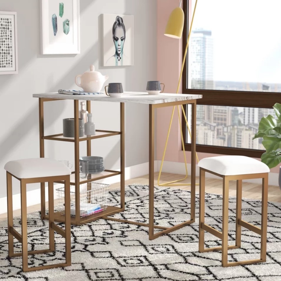 A white and gold steel dining set with two chairs and one table with three shelves