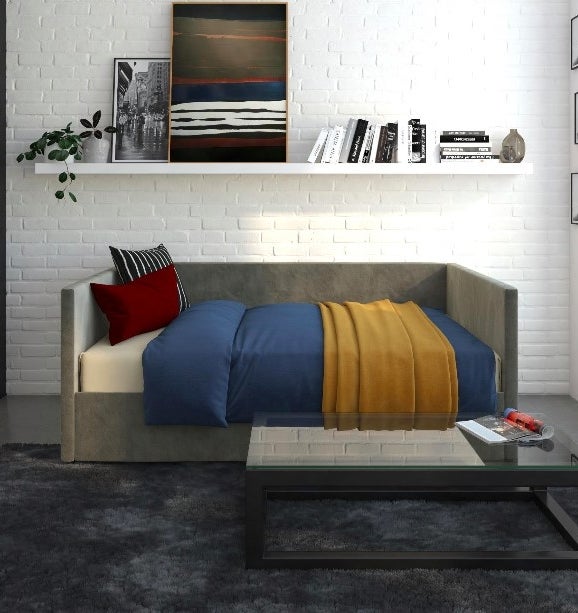 Gray daybed made into a comfy bed in a living room
