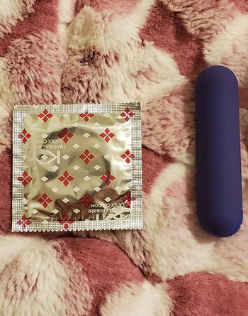 Blue bullet vibrator next to condom