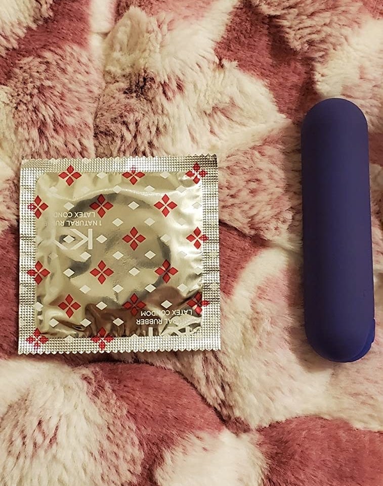 Blue bullet vibrator next to condom