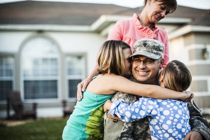 A family hugs military dad