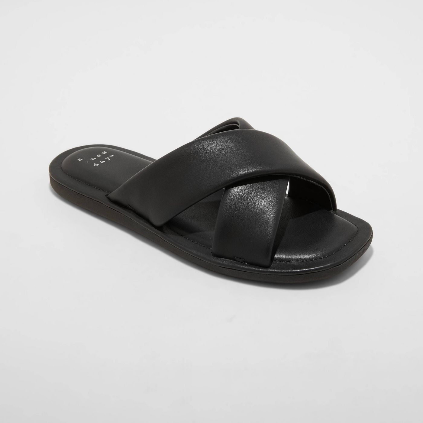 Black leather slides with black puffy sole, black stitching around the show