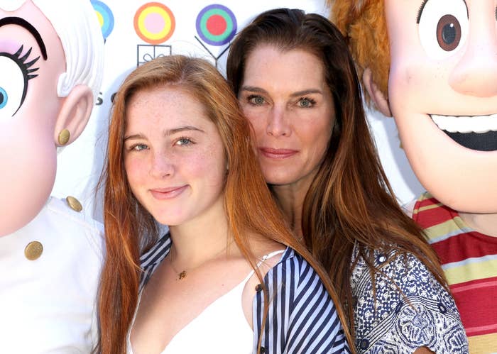 Rowan stands in front of Brooke as they pose at an event