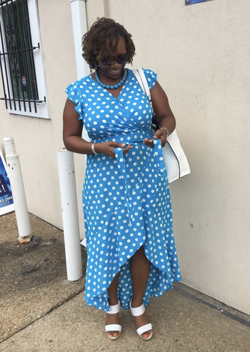 reviewer wearing the blue and white polka dot dress