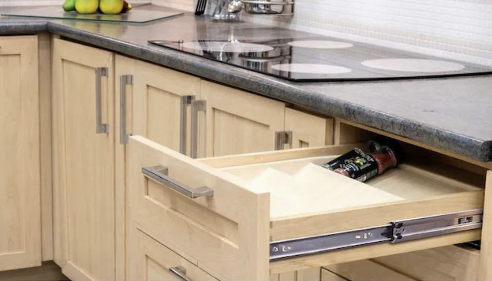 A kitchen with an open soft-close drawer