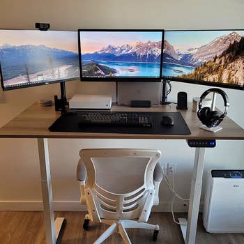 reviewer photo of the desk with three monitors on it