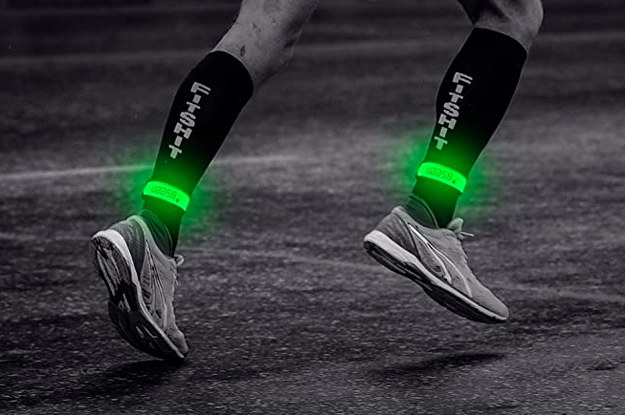 Model wears green glow-in-the-dark bands on their ankles while they run at night