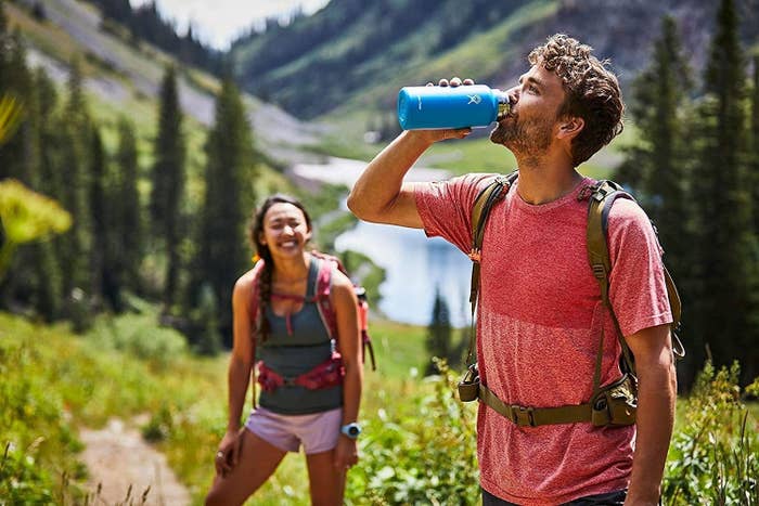 A model drinks from a blue Hydroflask
