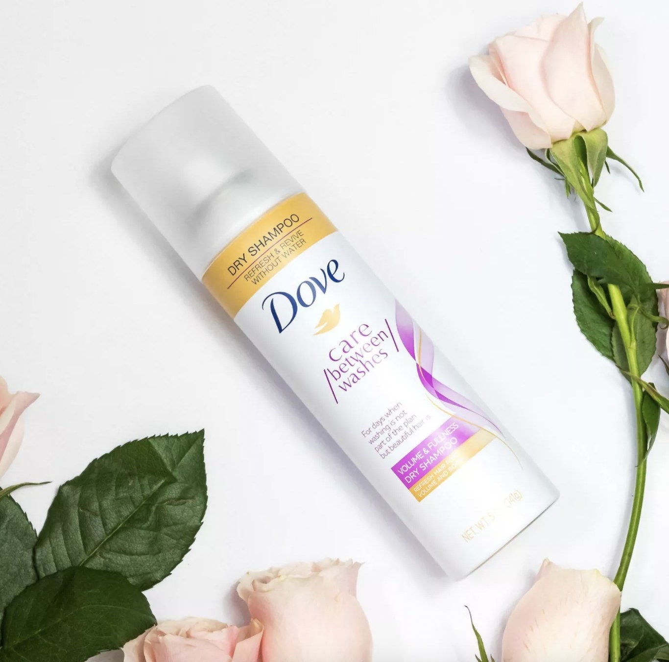 A bottle of dry shampoo and roses