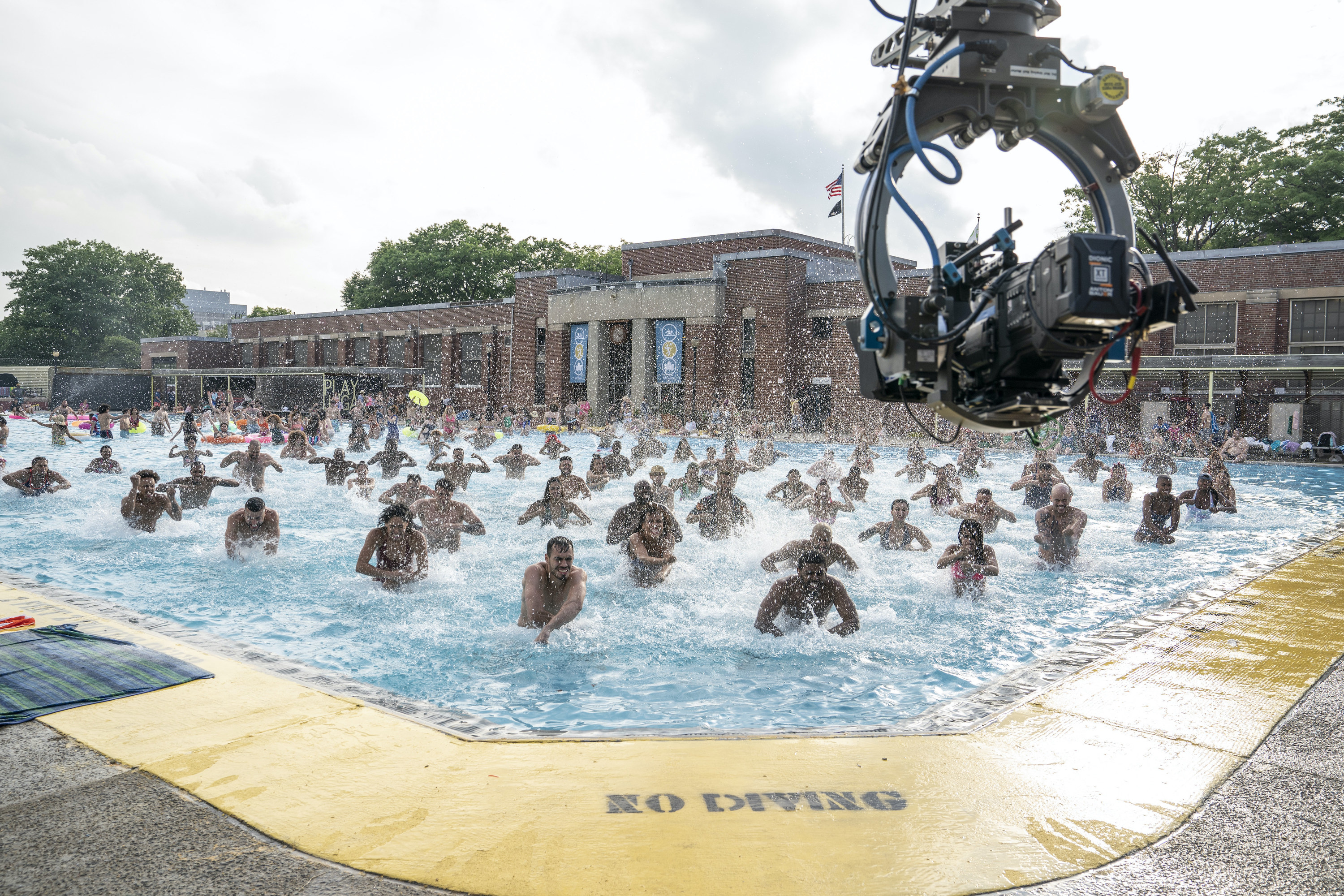 A big camera rig shooting the people dancing in the pool from above