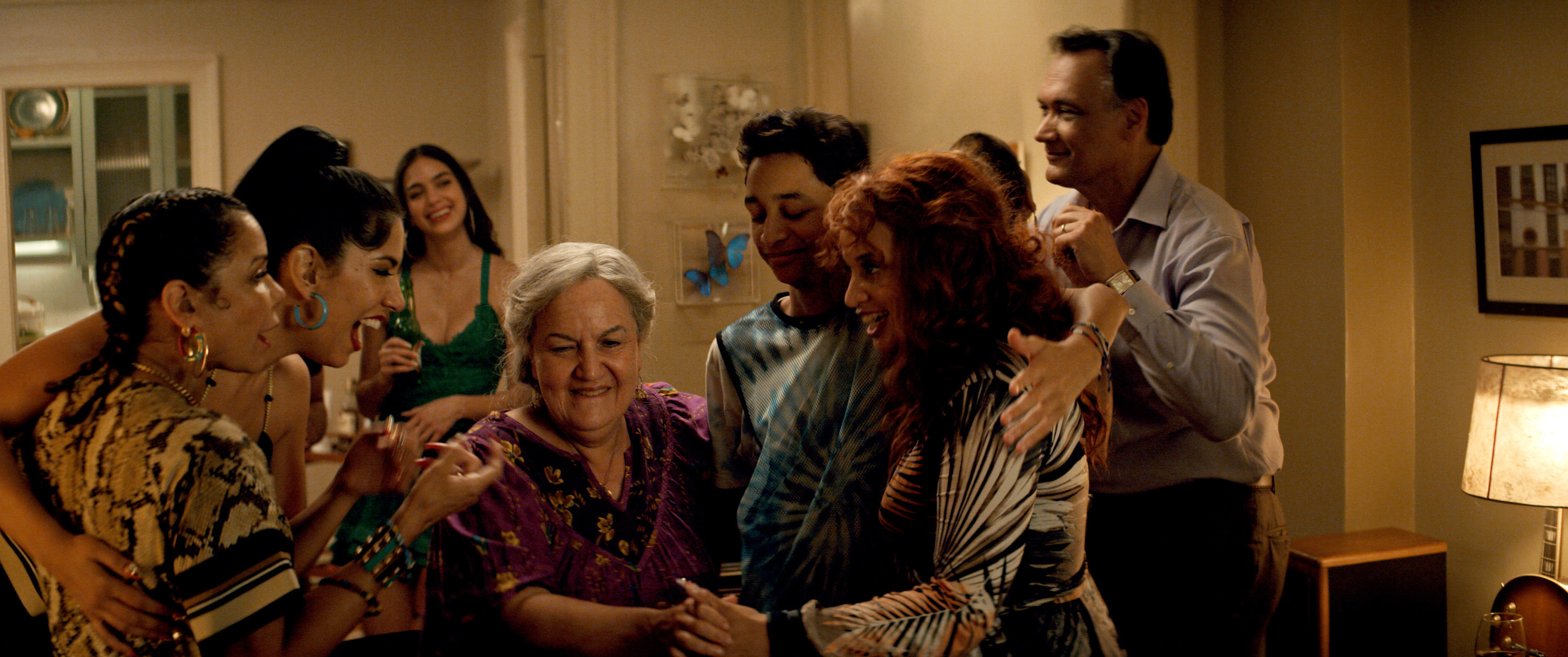 The cast of In The Heights hugging Abuela Claudia in the film