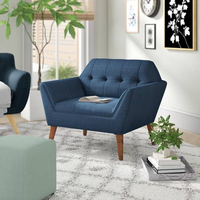 blue tufted upholstered angular armchair with wood legs