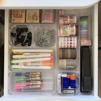 reviewer's desk drawer with clear bins organizing it