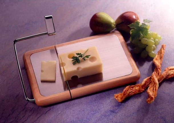 The cheese tray with slicer shown cutting a block of swiss cheese