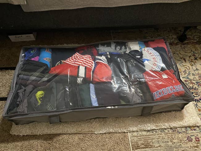 reviewer photo of an underbed storage bin filled with t shirts and leggings