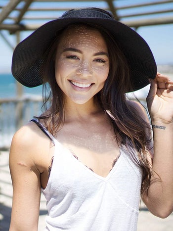 Model wearing the straw hat in black