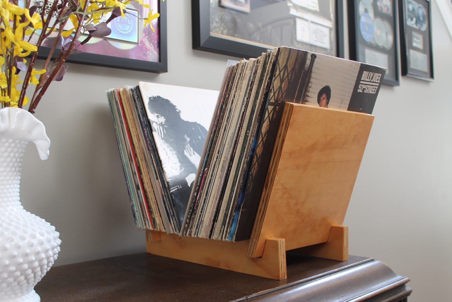 wooden vinyl holder with dozens of vinyls in it