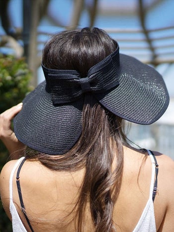 the back of the hat, fastened with a straw bow