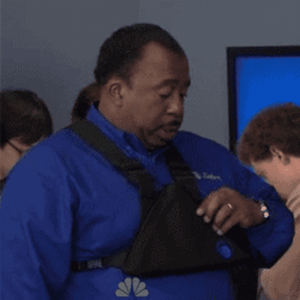 Stanley from The Office eating pizza out of a fanny pack