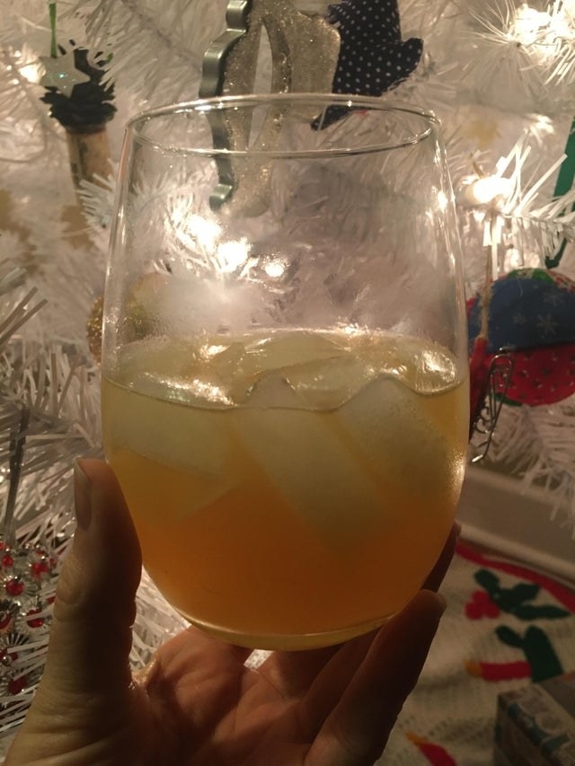 A sparkling cider cocktail in a stemless wine glass.