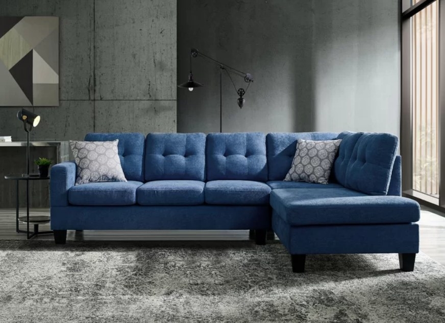 A sea-blue sectional with chaise sofa displayed on a grey rug in a living room