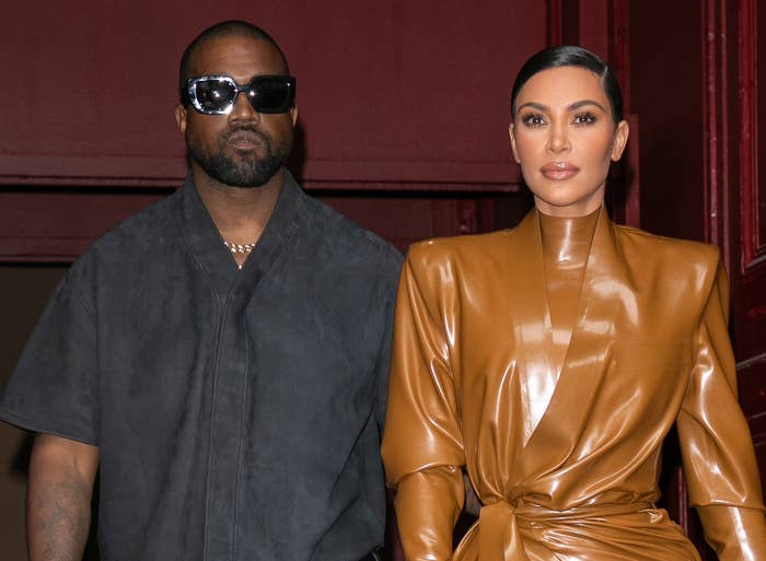 Kim and Kanye walk arm in arm while leaving a building
