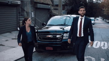Two FBI agents exit a car, ready for work