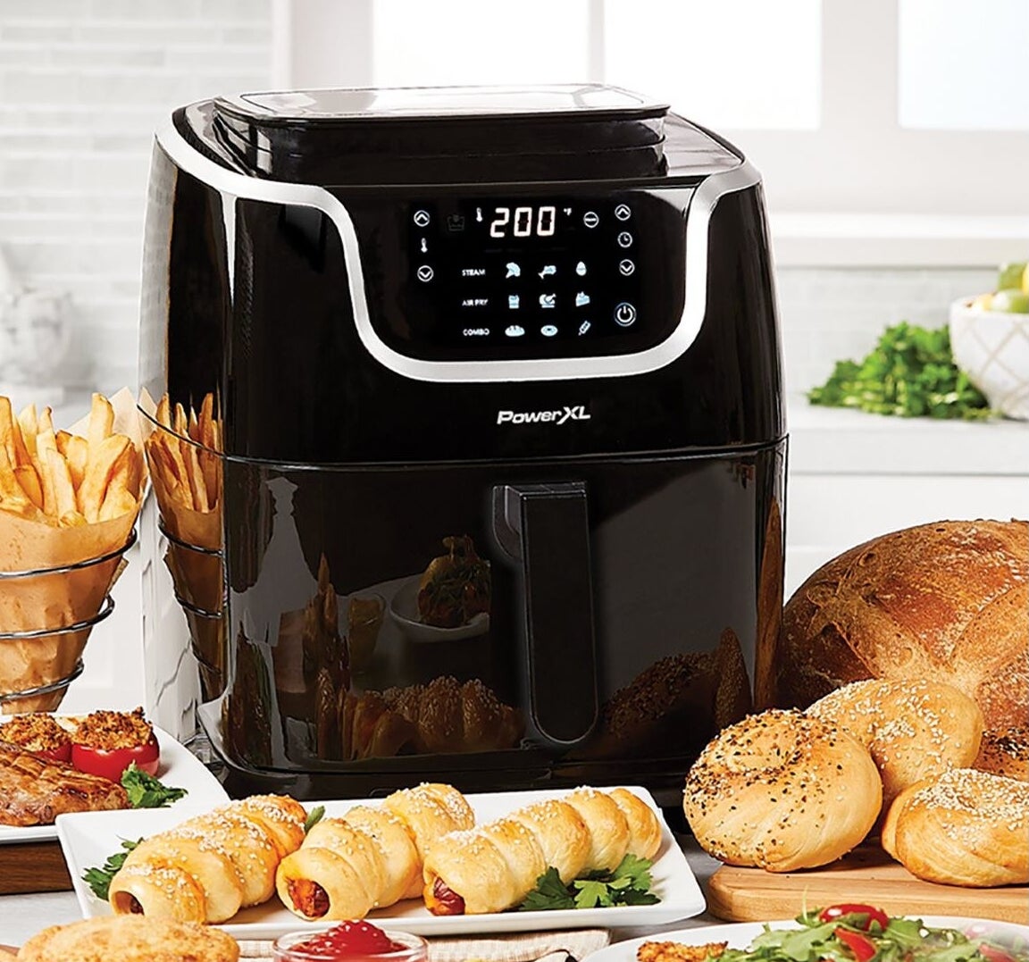 an air fryer surrounded by food