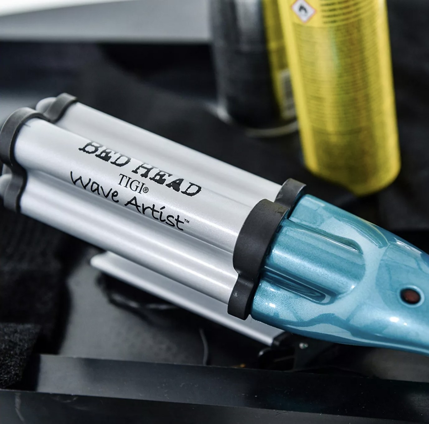 A heat-styling tool with a can of hairspray