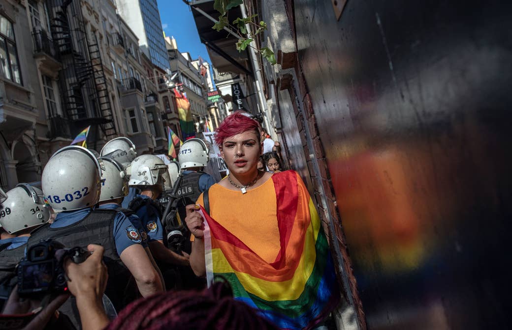 A person holding a pride flag walks the opposite direction of police