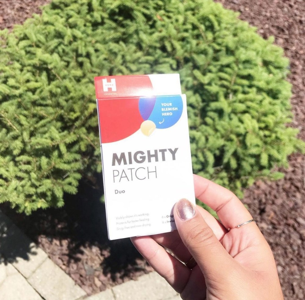 A 12ct pack of Might Patch acne patches being held by a model