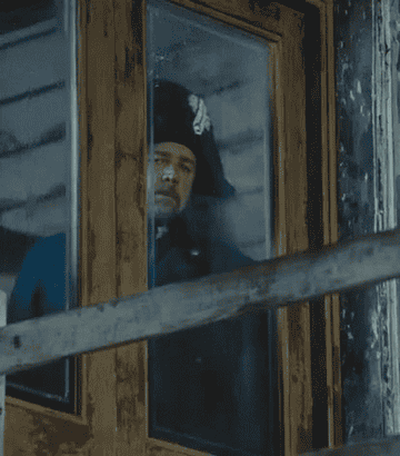Russell Crowe as Javert staring through a window