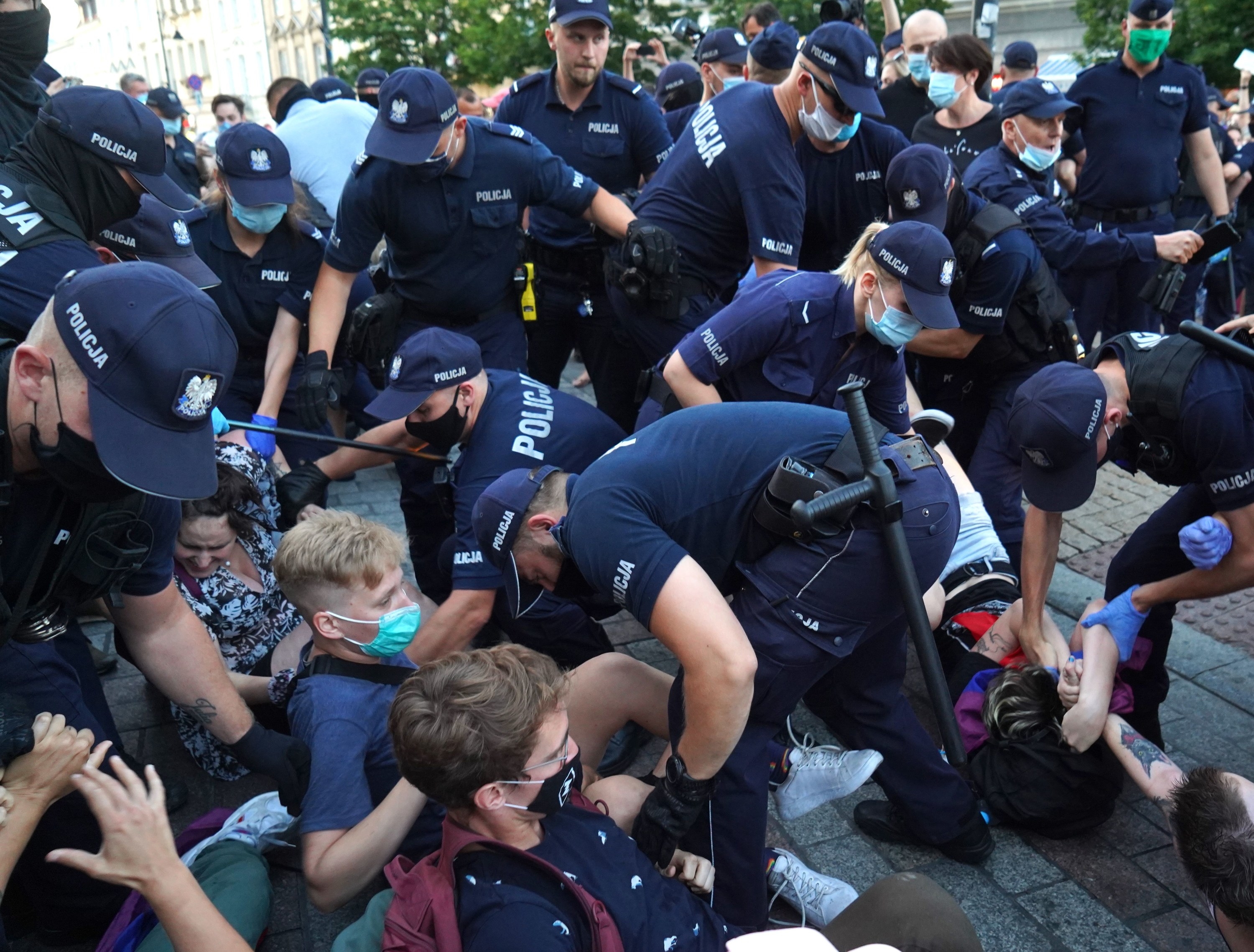 Officers surround and try to remove protesters sitting and lying on the ground