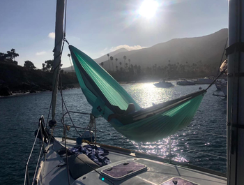 reviewers sleeping in the hammock attached to their sail boat 
