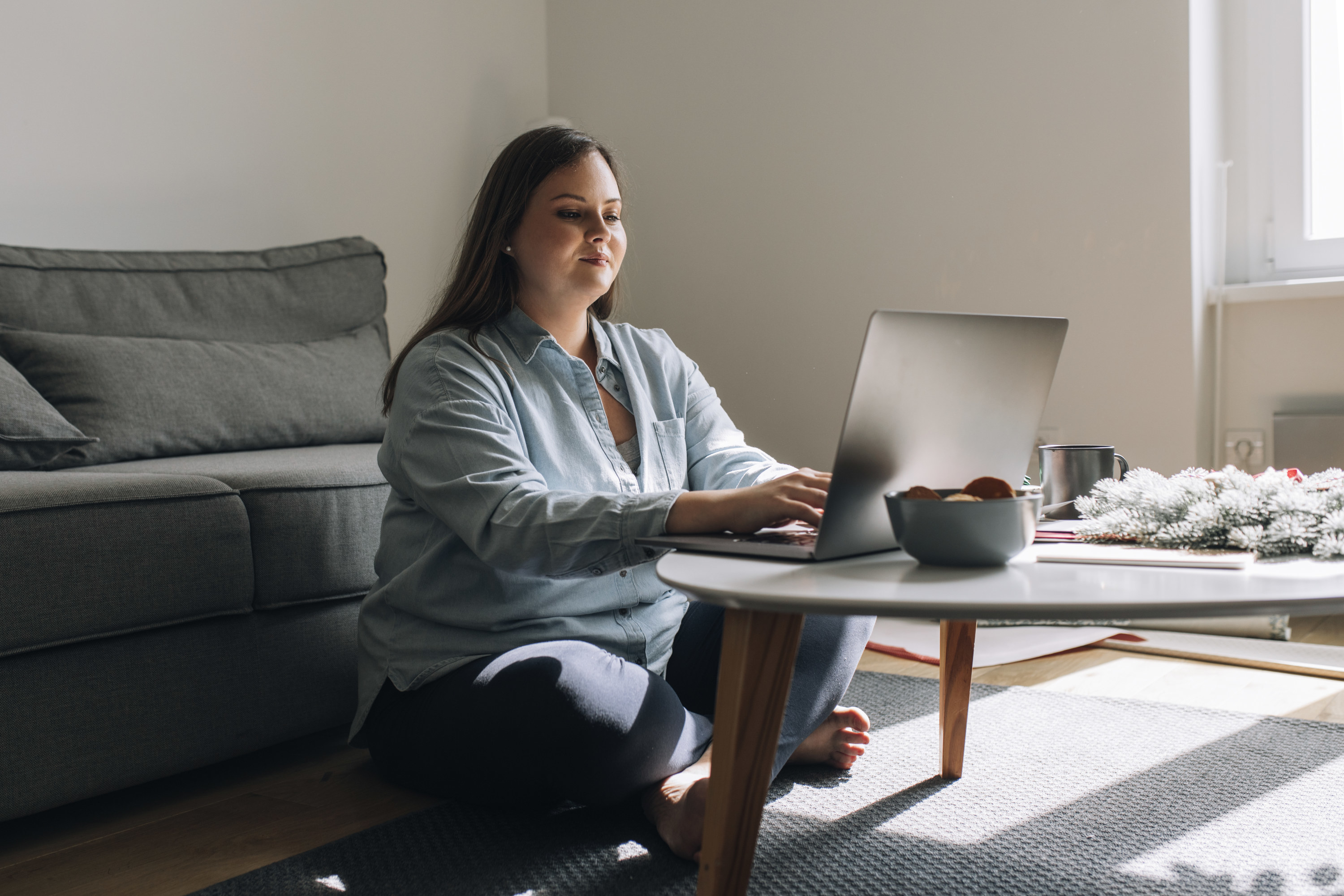 Woman writing a résumé on her laptop at home