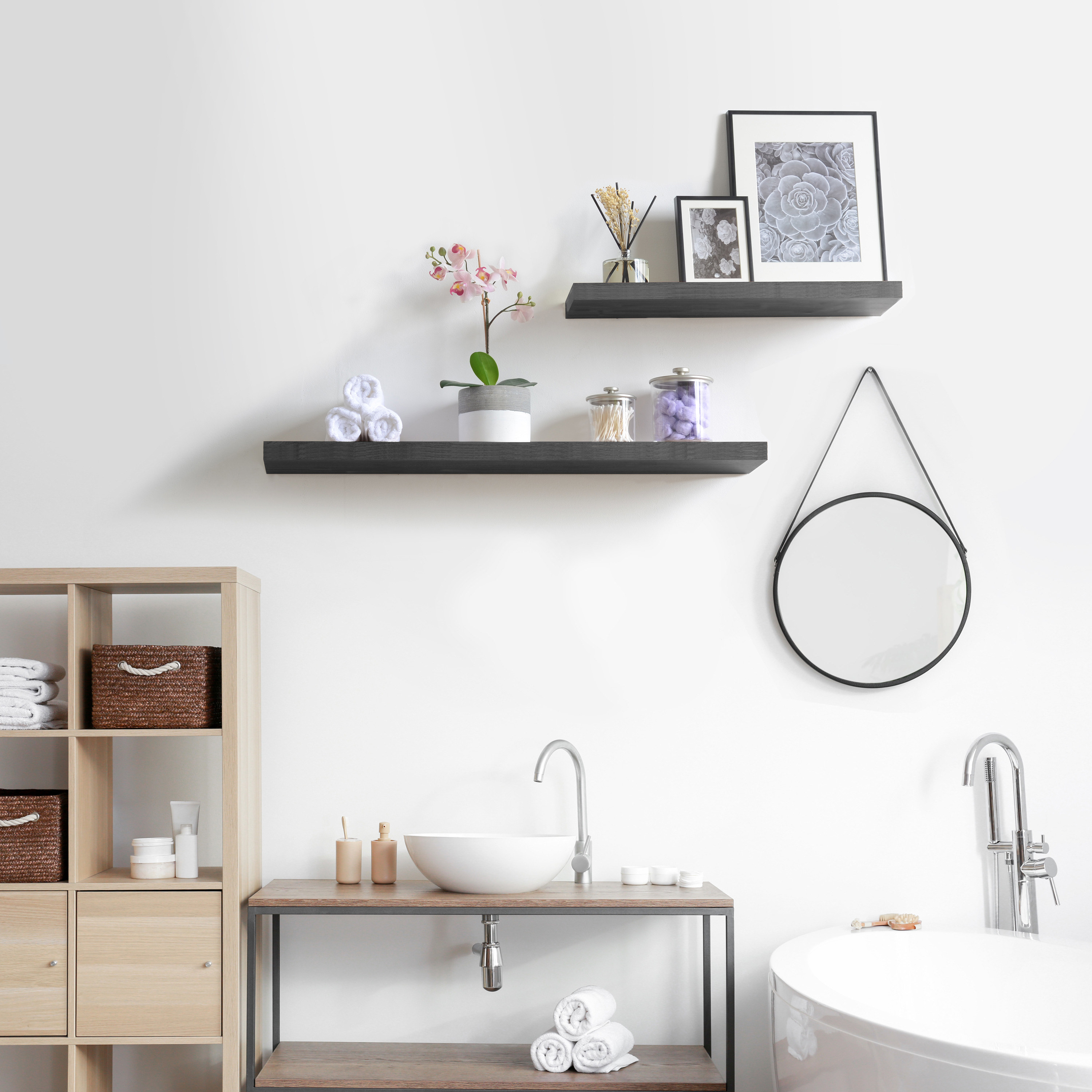 two floating black shelves with photos and faux plants