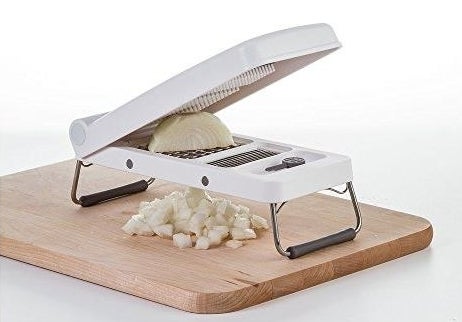 a vegetable chopper cutting an onion over a cutting board