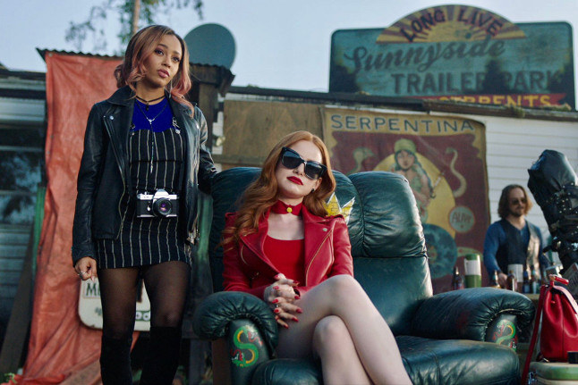 Madelaine Petsch sits on the serpent throne with Vanessa Morgan at her side. 