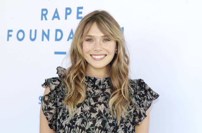 Elizabeth smiles in a floral dress with fluttery sleeves