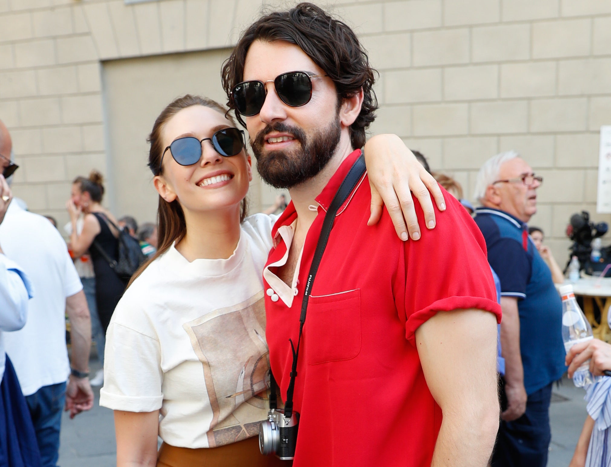 Elizabeth puts her arm around Robbie while outdoors in Italy