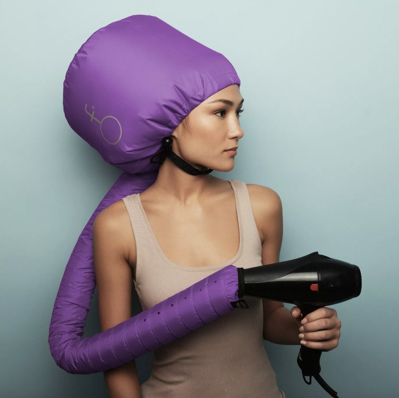 A woman with a hair dryer attachment and a blow dryer